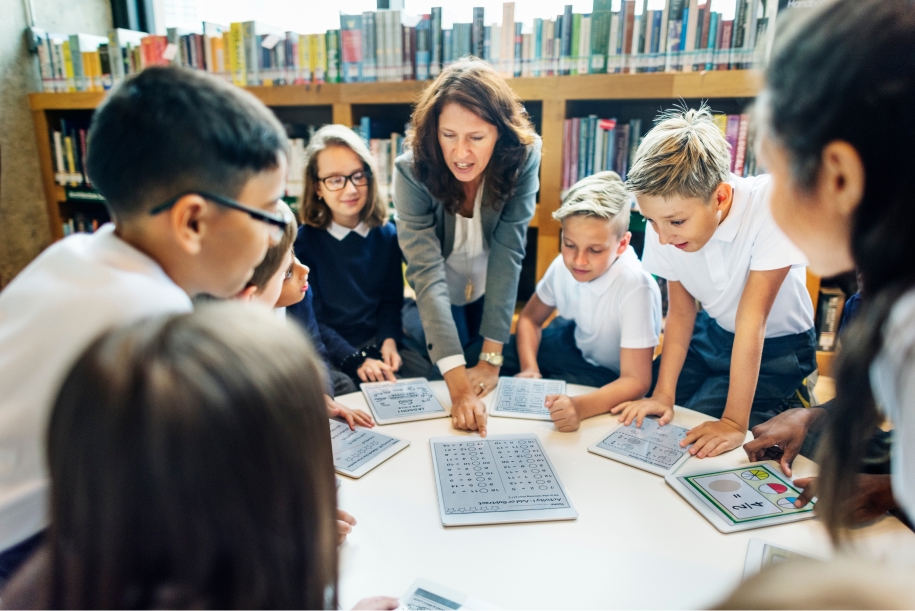 Teacher guiding students in a library classroom